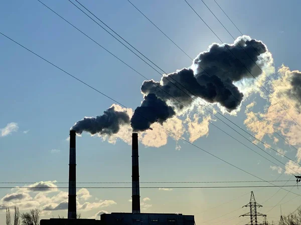在蓝天的映衬下从工业烟囱冒出的烟.城市环境中的工厂烟囱冒出的烟。概念：环境污染. — 图库照片