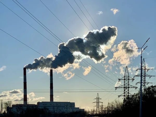 Rauch aus Industrieschornsteinen vor blauem Himmel. Rauch aus Fabrikschornsteinen in einer städtischen Umgebung. Konzept Umweltverschmutzung. — Stockfoto