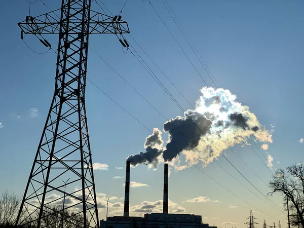 在蓝天的映衬下从工业烟囱冒出的烟.城市环境中的工厂烟囱冒出的烟。概念：环境污染. — 图库照片