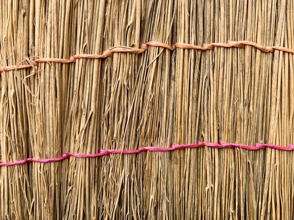 Background texture: straw broom, close-up. Part of the roof of a thatched hut. — Stock Photo, Image