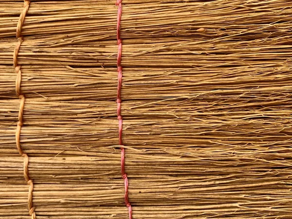 Background texture: straw broom, close-up. Part of the roof of a thatched hut. — Stock Photo, Image