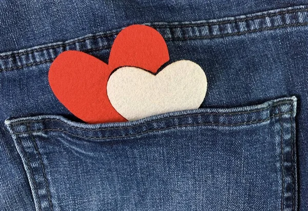 Twee harten in de achterzak van jeans. Achtergrondtextuur, zak met hartje op blauwe jeans. — Stockfoto