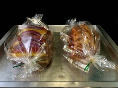 Siyah arka planda, sebzeli büyük bir parça kızarmış et. Biber ve baharatlı biftek pirzolası. Fırında pişirmek için domuz eti ve dana eti..