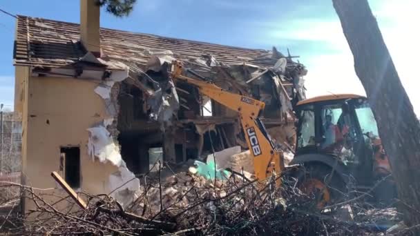 파괴된 근처의 중장비들 폐허를 배경으로 기계들 굴착기가 철거하는 키예프 지역의 — 비디오