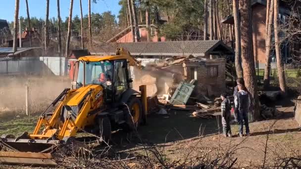 파괴된 근처의 중장비들 폐허를 배경으로 기계들 굴착기가 철거하는 키예프 지역의 — 비디오