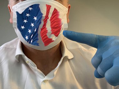 Amerikan bayrağı taşıyan tıbbi maskeli bir adam. Erkek yüzü koruyucu bir tıbbi maskeyle kaplı. Eldivenli bir el. Konsept: koronavirüs salgını, zatürree yayılması, salgın hastalık, Covid-19