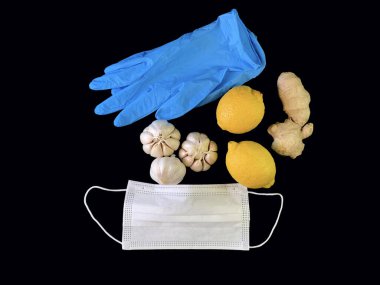 Siyah arka planda sarımsak, zencefil, elma ve turunçgil meyveleri. Masada doğal vitaminler, portakallar, greyfurt ve mandorin. Konsept: Evde viral enfeksiyon ve korovirüsün önlenmesi.