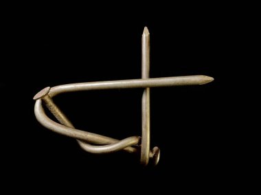 Siyah arka planda bükülmüş metal tırnaklar. Büyük bir çivi düğümlenir. Kavram: Sonsuza dek birlikte, güç birliği.