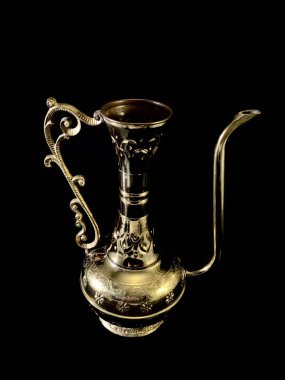 Siyah arka planda bakır antika vazo. Bronz kaplar, desenler ve süslemeler. Evin dekorasyonu için altın sürahi..