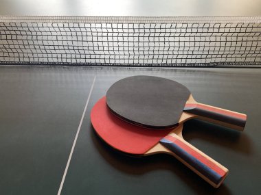 Tenis masasında pinpon raketleri. Arka planda masa tenisi raketi. Konsept: masa sporu.