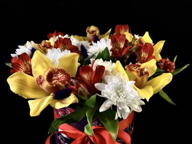 Güzel bir buket çiçek. Siyah arka planda çok renkli çiçekler. Bahar buketi, sarı, beyaz ve kırmızı karışımı..