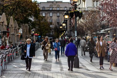 Belgrad şehir merkezinde kalabalık bir yaya bölgesinde yürüyüş yapan insanlar