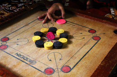 Tahtadaki carromlu parçalarla bir carrom oyunu. Carom masa oyunu, seçici odaklanma..