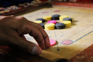 Tahtadaki carromlu parçalarla bir carrom oyunu. Carom masa oyunu, seçici odaklanma..