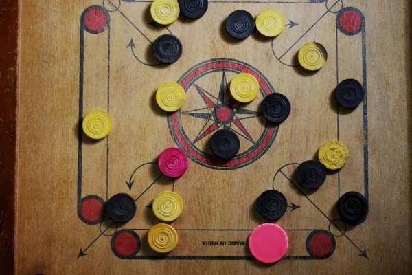 Un juego de carrom con piezas hombre carrom en el tablero de carom apilamiento.Un juego de carom set y listo para jugar —  Fotos de Stock