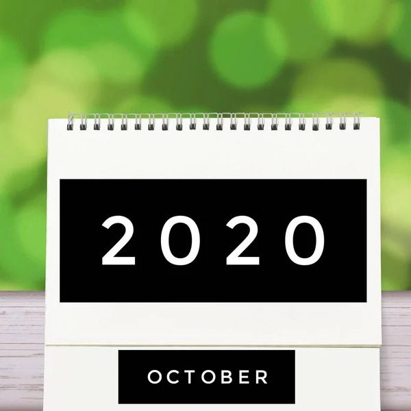 Biały pusty papier biurko spirala Październik kalendarz na drewnie z zielonym abstrakcyjnym tle. Kalendarz 2020 i pusty miesiąc lub data wprowadzenia tekstu i numerów. — Zdjęcie stockowe