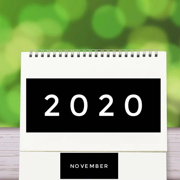 Branco mesa de papel em branco espiral Calendário de novembro sobre madeira com fundo abstrato verde. Calendário de 2020 e mês ou data vazia para inserir texto e números . — Fotografia de Stock