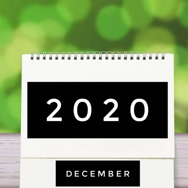 Biały pusty papier biurko spirala Grudzień kalendarz na drewnie z zielonym abstrakcyjnym tle. Kalendarz 2020 i pusty miesiąc lub data wprowadzenia tekstu i numerów. — Zdjęcie stockowe