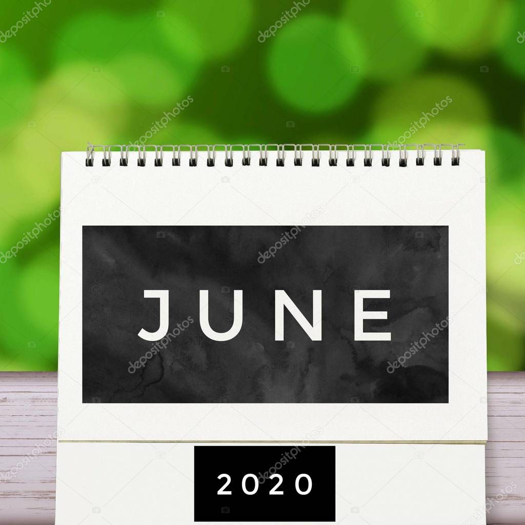 White blank paper desk spiral June calendar on wood with green abstract background. Calender of 2020 and empty month or Date to enter text and numbers.
