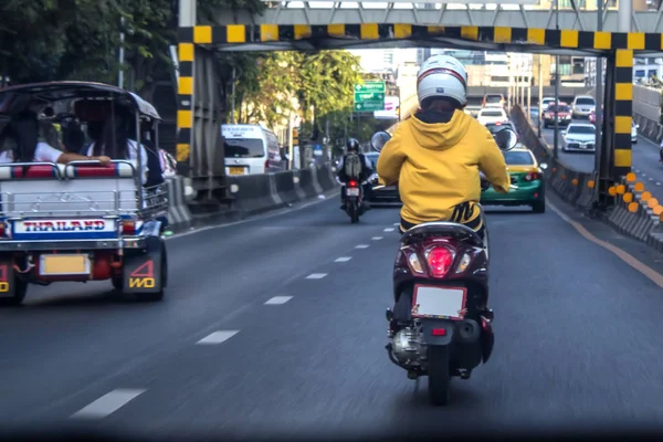 Motocicleta y coches están cabalgando en la calle Imágenes de stock libres de derechos