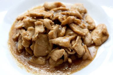 Beyaz bir tabakta sarımsak, biber ve domuz kızartması..