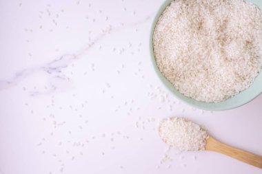 Mermer bir masada pirinç dolu seramik yeşil tabak. Pirinçli tahta kaşık. sağlıklı beslenme