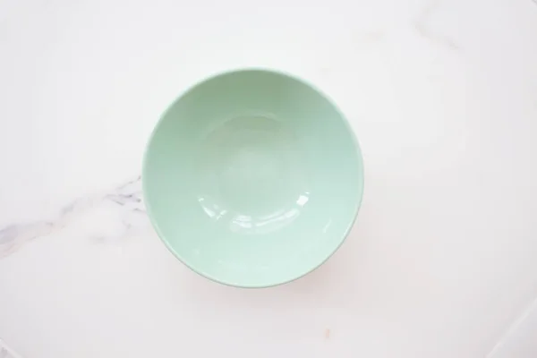 Talerz na białym marmurze. zielona ceramiczna miska na białym marmurowym tle. widok z góry — Zdjęcie stockowe
