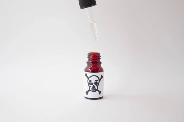 Bottle with poison and a sign of death. drop of poison on a medical dropper — 스톡 사진