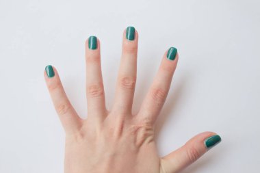  Güzel koyu yeşil tırnak cilası kadın manikürü. Spa konsepti, minimalizm. Üst görünüm.