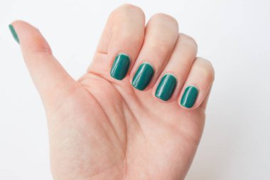  Güzel koyu yeşil tırnak cilası kadın manikürü. Spa konsepti, minimalizm. Üst görünüm.