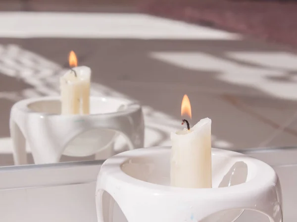 Hořící svíčka v zrcadlovém odlesku v bílém svícnu. Koncept sezení a věštění osudu — Stock fotografie
