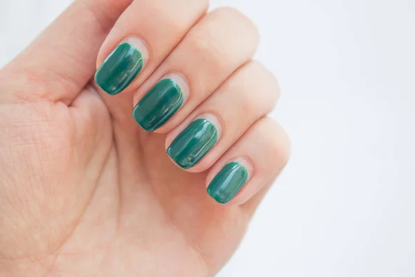 Damaged female nail with green manicure. Peeled off gel polish with nails. Home manicure concept — Stock Photo, Image