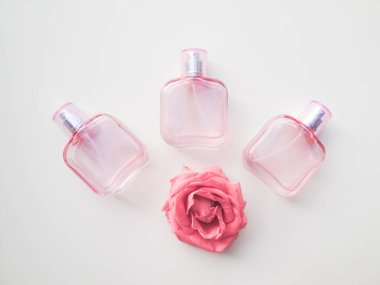  Beyaz arka planda renkli kozmetik şişeler, ampuller, tüpler, kutular. Çiçekli pembe şişeler, aroma konsepti.