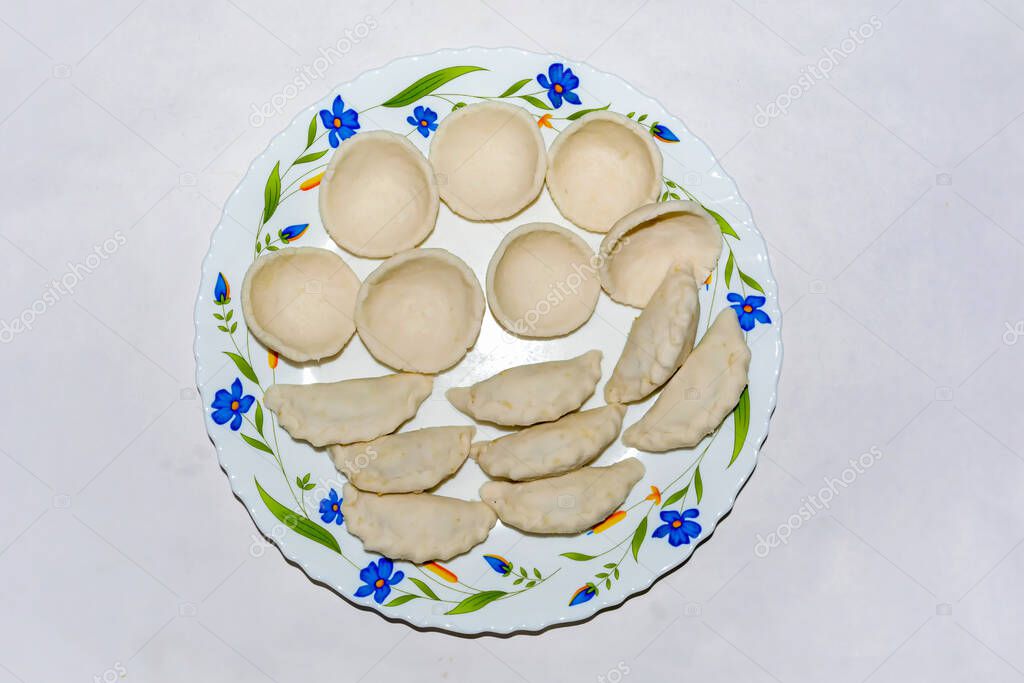 Cocina bengalí puli pitha en un plato de cerámica sobre fondo blanco