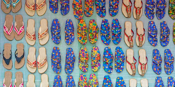 Rows of traditional colorful flip flop and slipper sandals are displayed for selling in a handicraft fair shop at Kolkata.