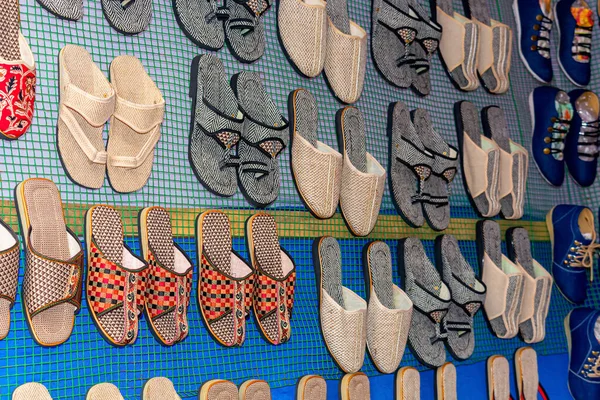 Rows of traditional colorful flip flop and slipper sandals are displayed for selling in a handicraft fair shop at Kolkata.Side angle view.