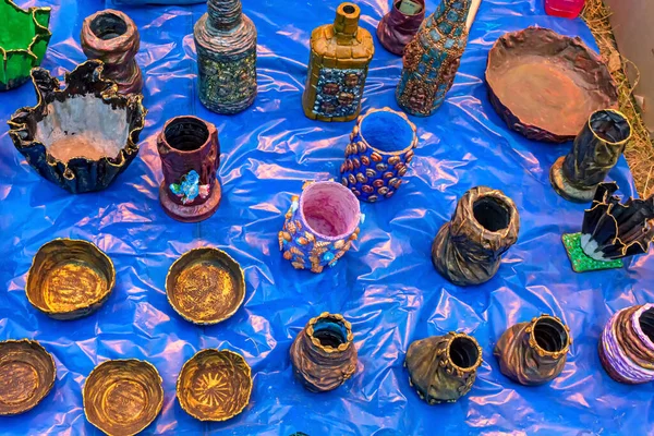 Vase, pen stand and bowl are made from waste component, displayed for sale at a handicraft fair.