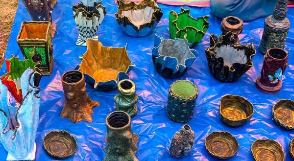 Vase, pen stand and bowl are made from waste component, displayed for sale at a handicraft fair.