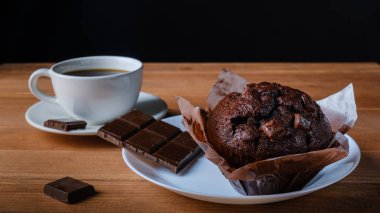 Lezzetli çikolatalı kek, çikolata ve bir fincan sade kahve.