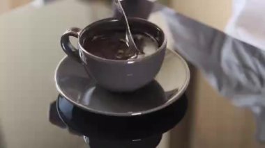 kız siyah kahve şeker karıştırır, siyah cam masada siyah kahve bir fincan