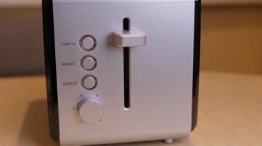 Kahvaltı hazırlıyorum. Bir kadın sabah mutfakta tost makinesini açar..