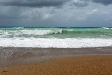 Rodos'ta Ege Denizi'nin kum sahilinde dalgalar.