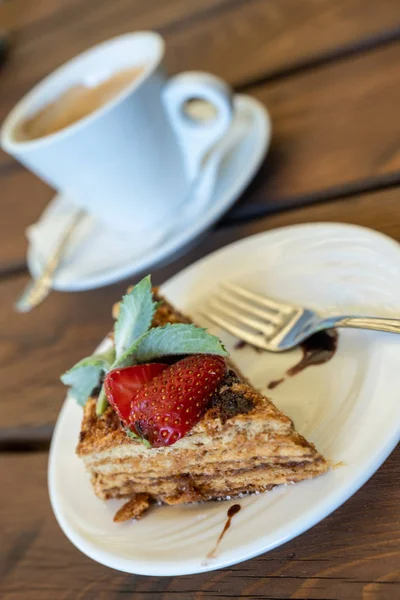 Eine Tasse Kaffee und ein Stück Honig Biskuitkuchen dekoriert mit — Stockfoto