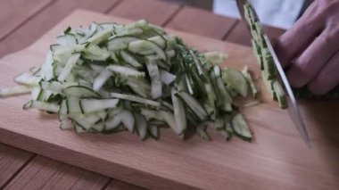 bir kesme tahtası üzerinde salatalık dilimler pişirmek, yakın çekim dilimleme salatalık