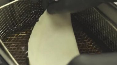 Şef Cheburek 'i kızgın yağda kızartıyor. Hamurda kuzu kızartması.