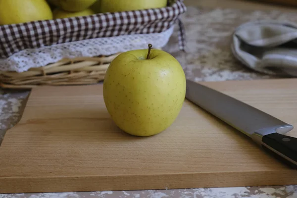 Messer und Apfel auf einem Schneidebrett auf einem Tisch in der Küche. ch — Stockfoto
