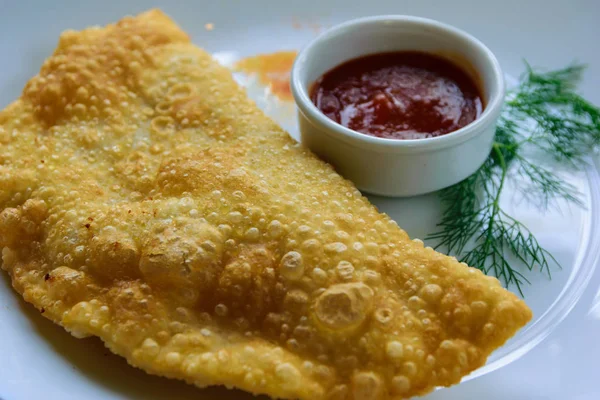 Cordero con cebolla y condimentos en la masa. Cheburek con sauc — Foto de Stock