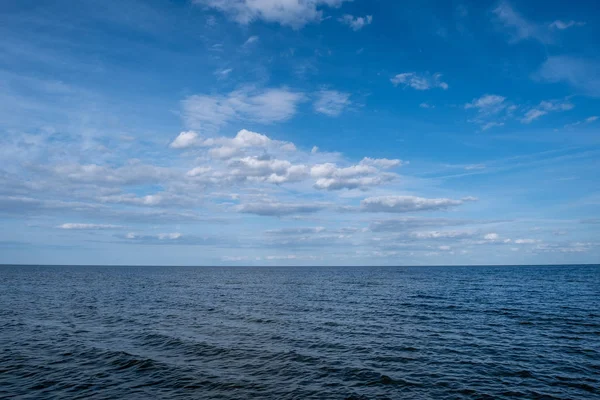 Baltické moře s malými vlnami a modrá obloha s bílými mraky. — Stock fotografie