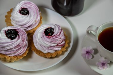 Beyaz arka plan üzerinde beze ve böğürtlen reçel ve Phlox çiçekler ile tatlı tartlet