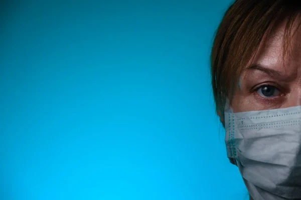 Woman wearing medical masks on blue background. Medical surgical flu illness protective mask textile. Prevent coronavirus, COVID-19.